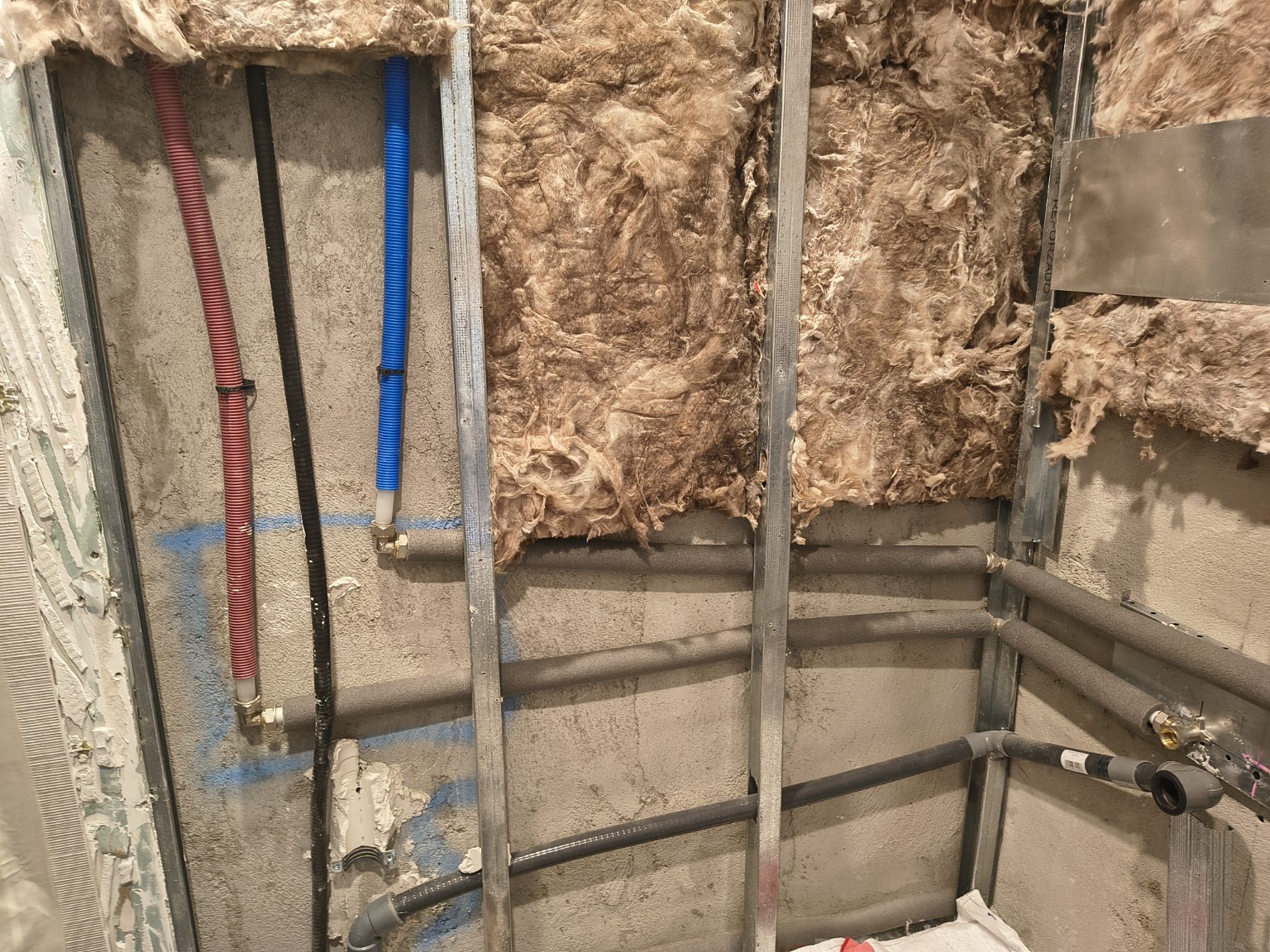 Water and waste pipes visible inside the open bathroom partition