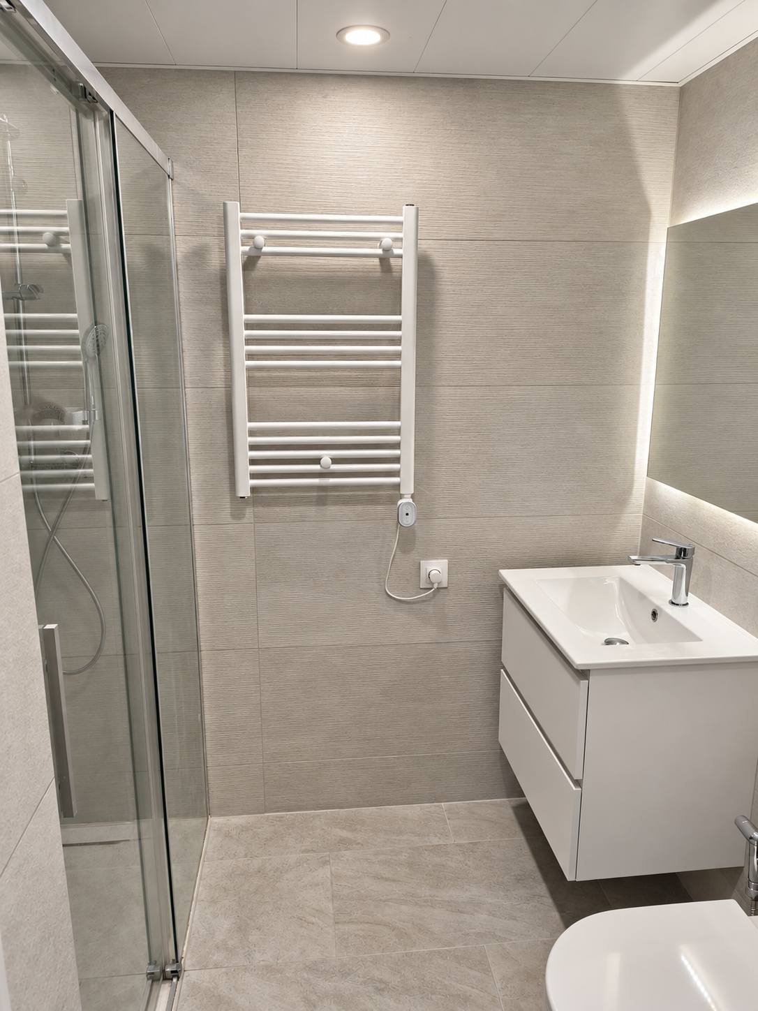 Bathroom with a glass shower, floating vanity and illuminated mirror