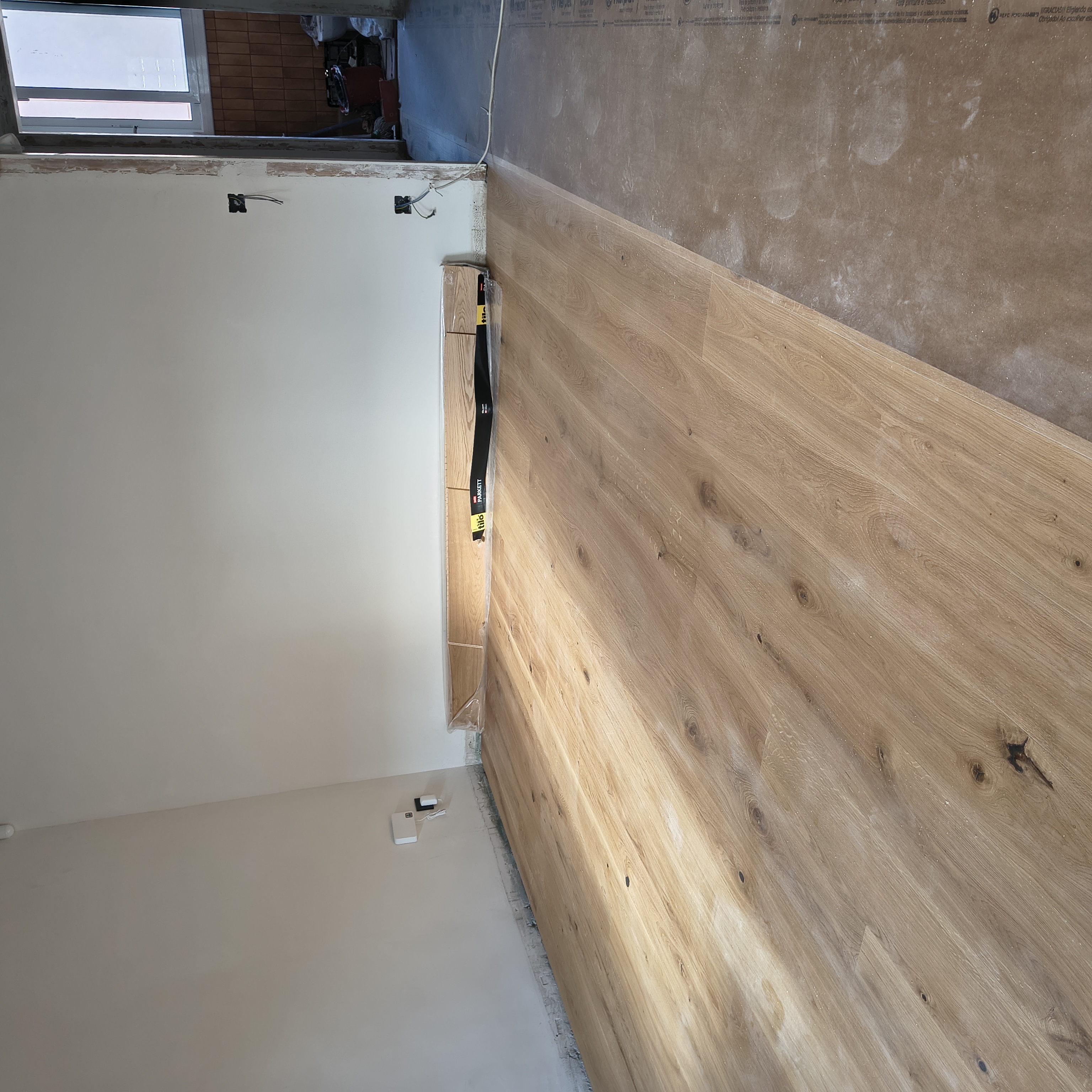 Parquet parcialmente colocado y zona protegida con cartón